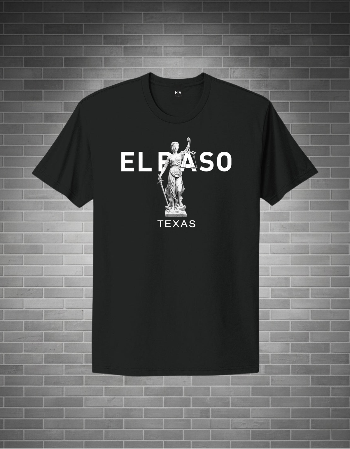 Black t-shirt with 'EL PASO TEXAS' text and statue graphic on a brick wall background