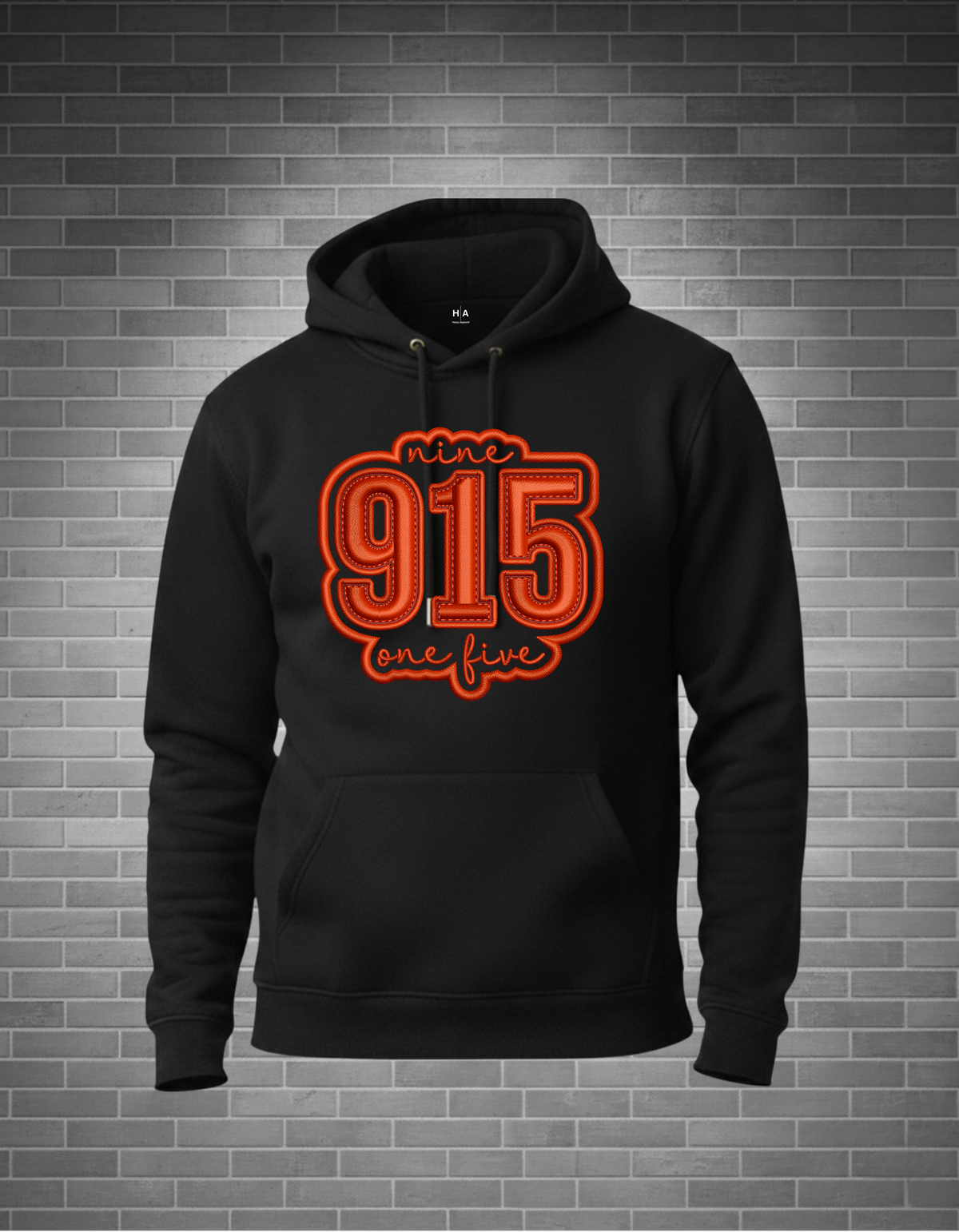 Black hoodie with red text '915 one five' on a brick wall background