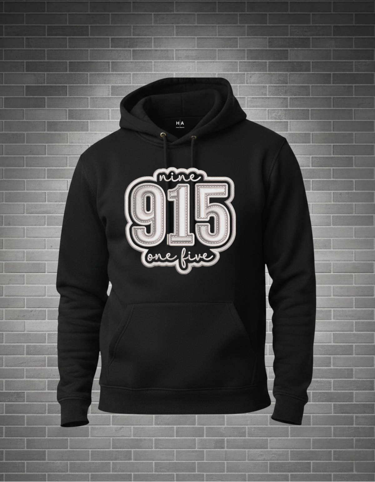 Black hoodie with '915 one five' in white text on a brick wall background