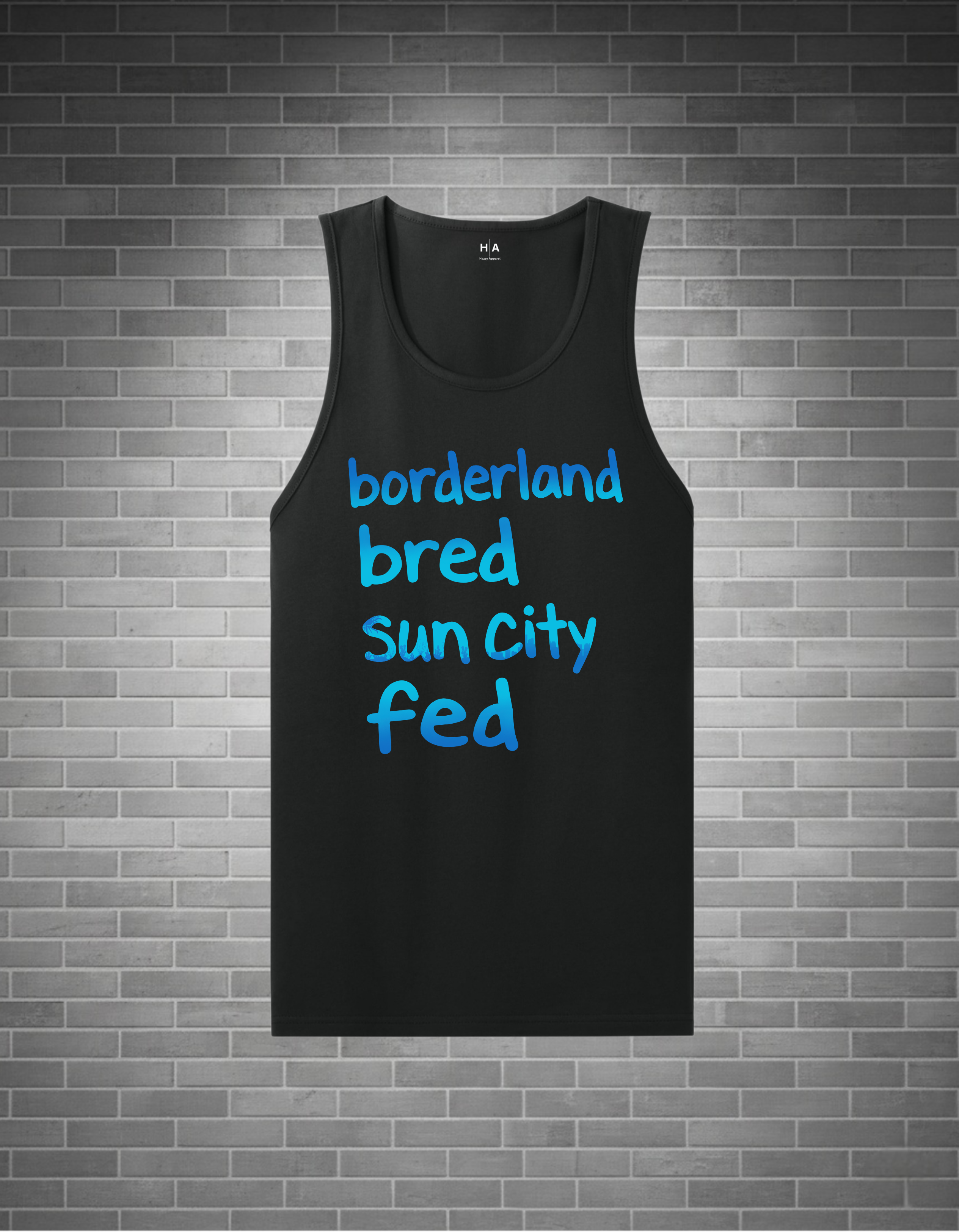 A black sleeveless tank top with the text 'borderland bred sun city fed' printed in bright blue across the front, displayed against a gray brick wall background.