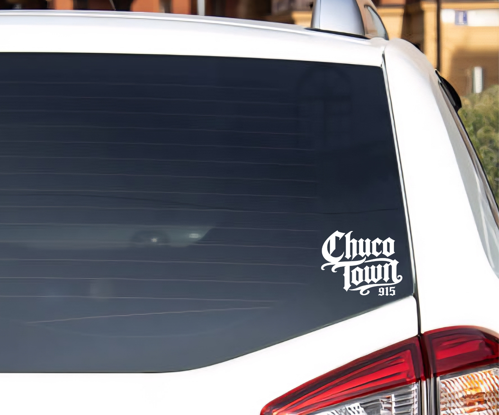 A white car rear window with a black decal reading 'Chico Town 915' in a stylized script font, photographed outdoors.