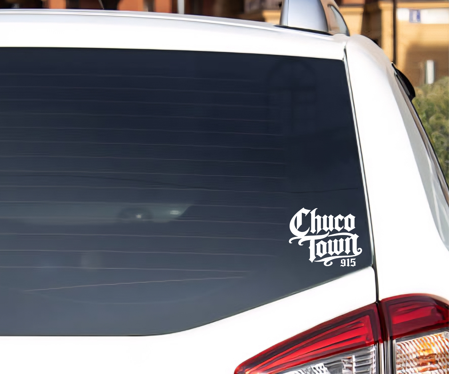 A white car rear window with a black decal reading 'Chico Town 915' in a stylized script font, photographed outdoors.