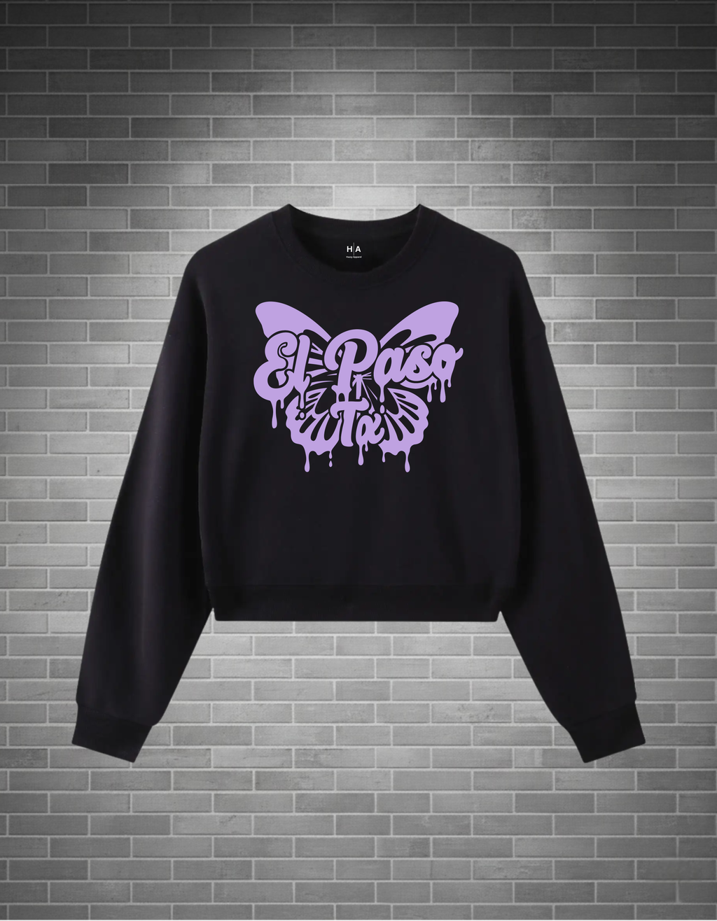 Black sweatshirt with a purple butterfly design on a brick wall background