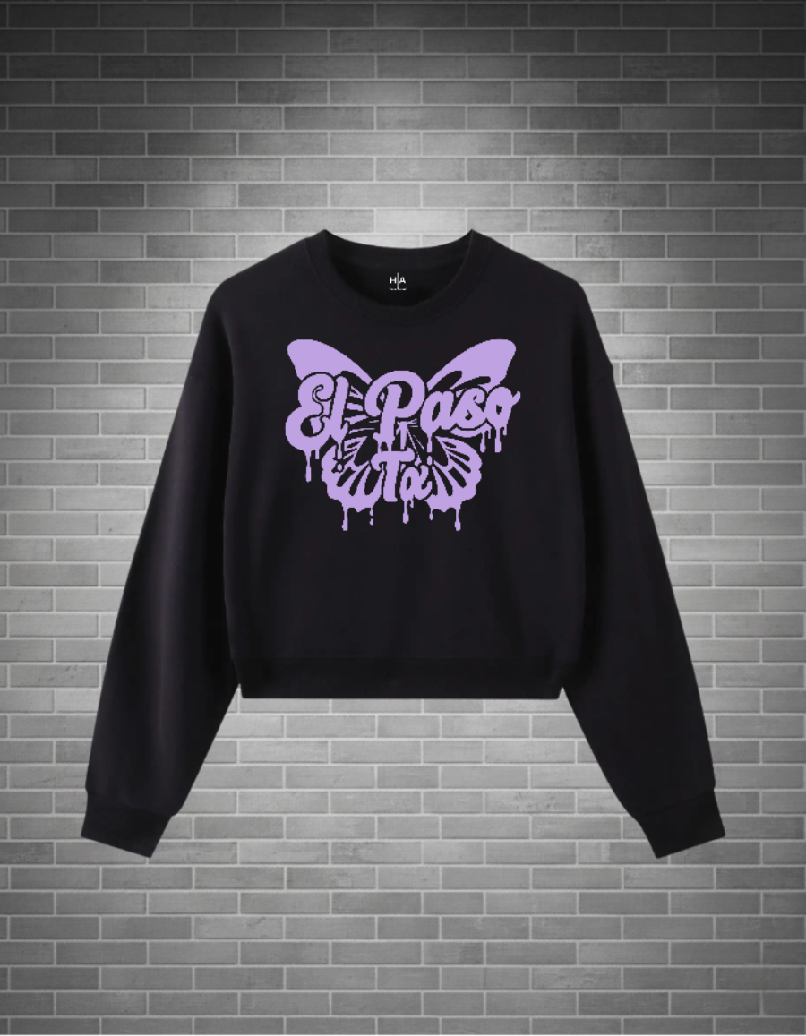 Black sweatshirt with a purple butterfly design on a brick wall background