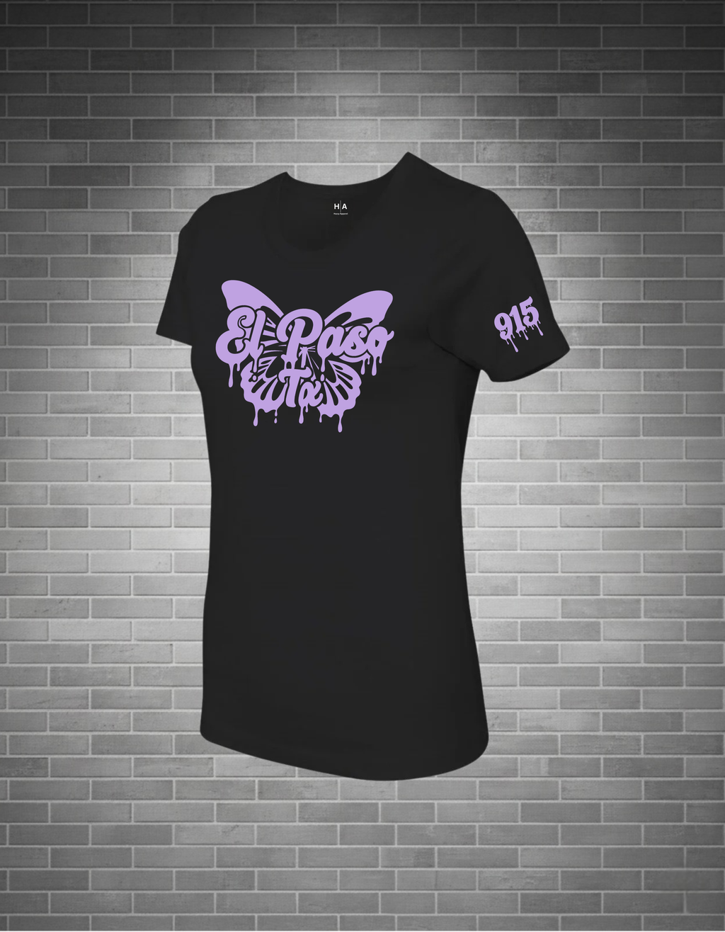 Black t-shirt with a purple butterfly design on a brick wall background