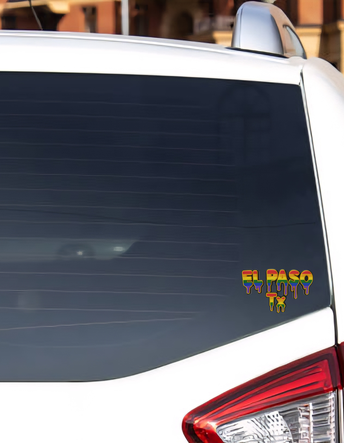 Car window with a 'El Paso Wino' sticker on a white car.
