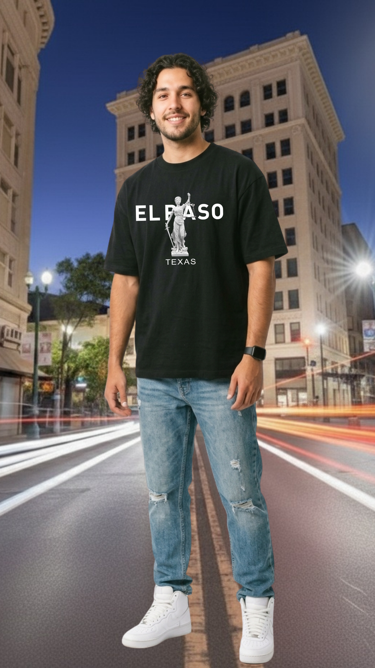 Man wearing a black t-shirt with 'El Paso Texas' design on a city street at night.