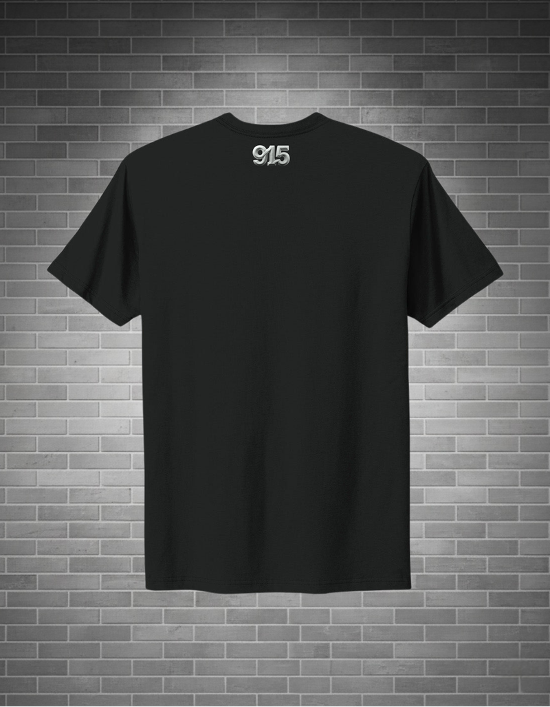 Black t-shirt with a logo on the back against a brick wall background