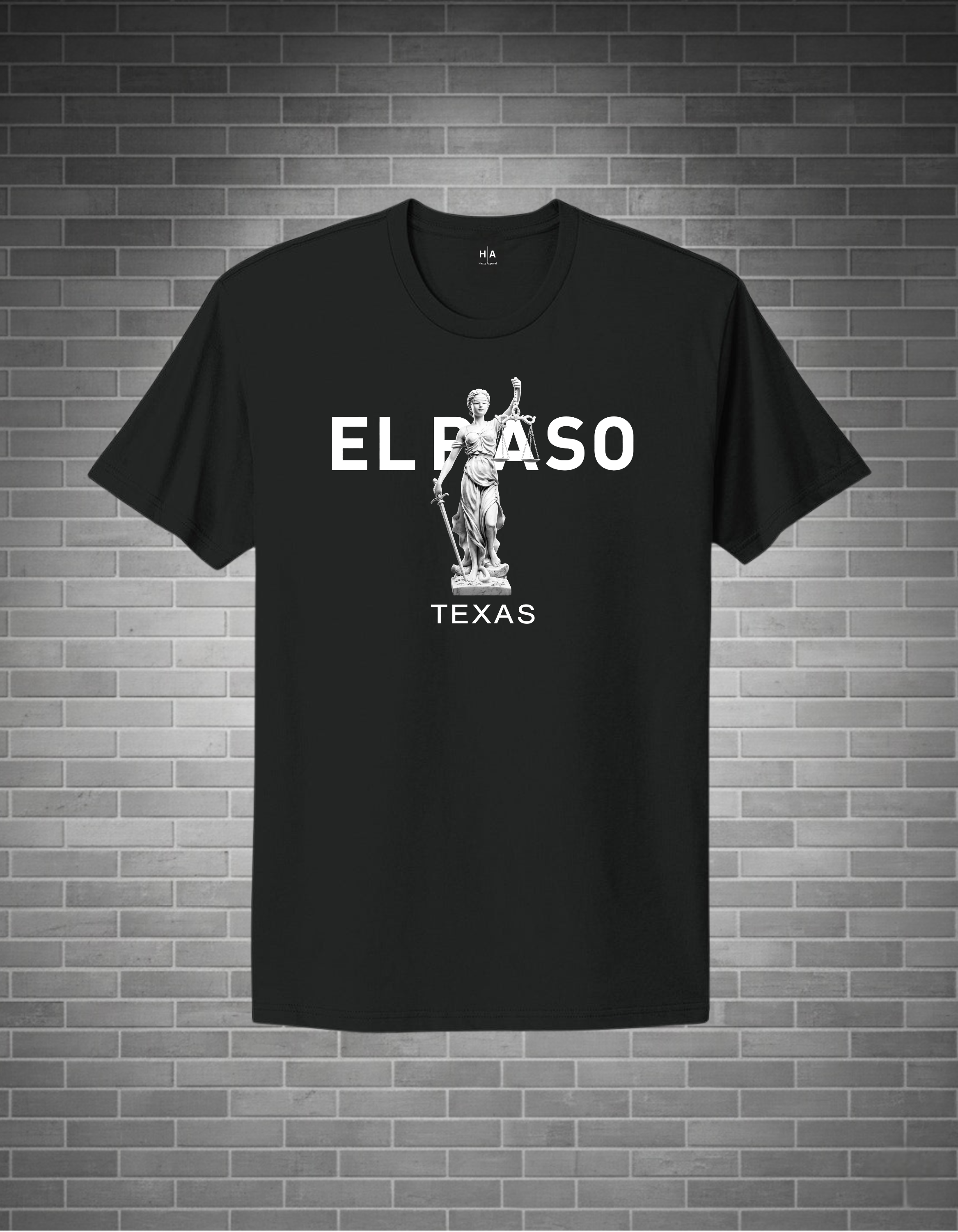 Black t-shirt with 'EL PASO TEXAS' text and statue graphic on a brick wall background