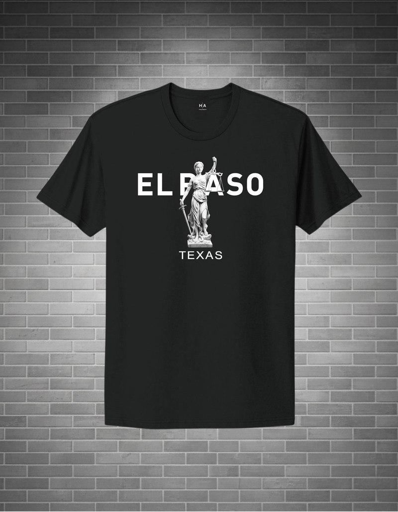 Black t-shirt with 'EL PASO TEXAS' text and statue graphic on a brick wall background