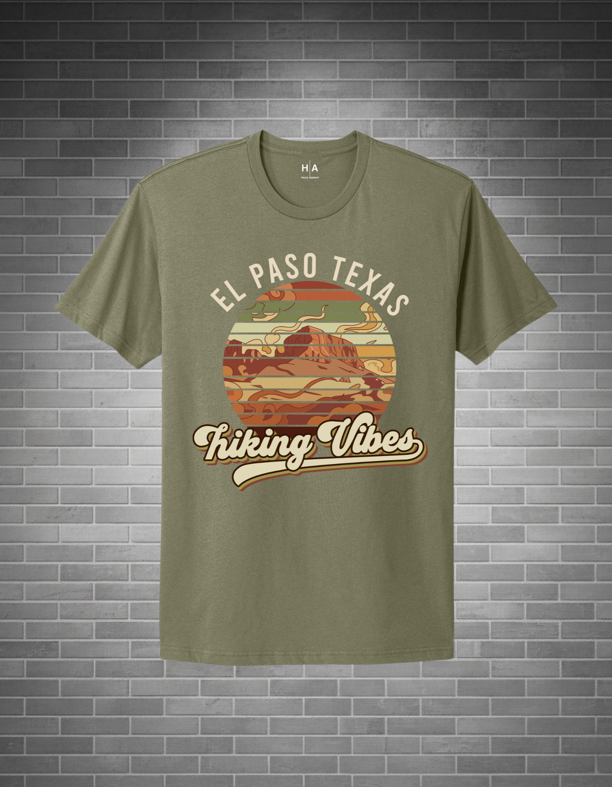 Green t-shirt with 'El Paso Texas Hiking Vibes' design on a brick wall background