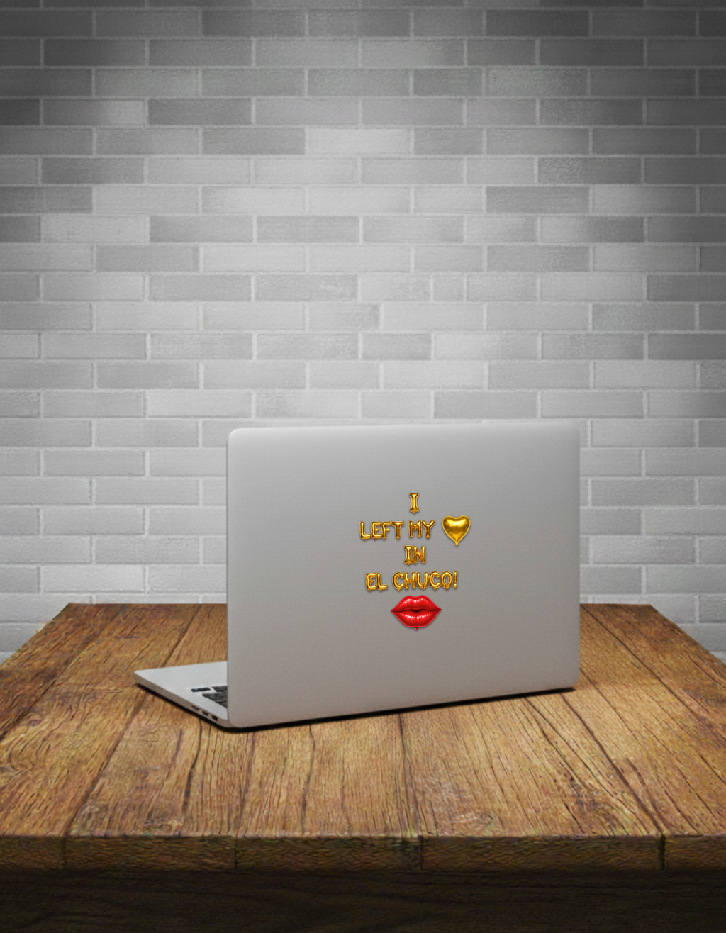 Laptop with a sticker on a wooden table against a brick wall background