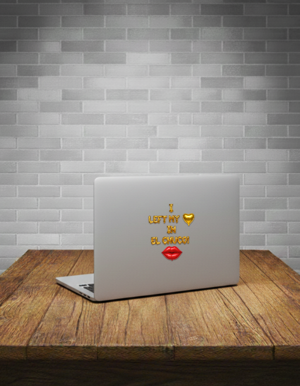 Laptop with a sticker on a wooden table against a brick wall background