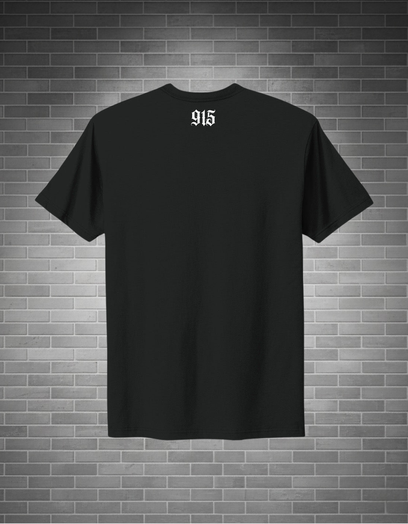 Black t-shirt with a logo on the back against a brick wall background