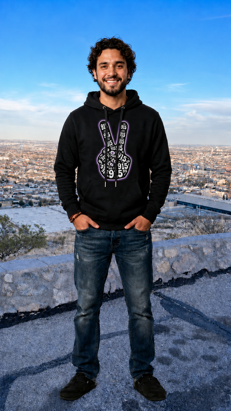 Person wearing a black hoodie with a white logo, standing on a high vantage point with a cityscape in the background.