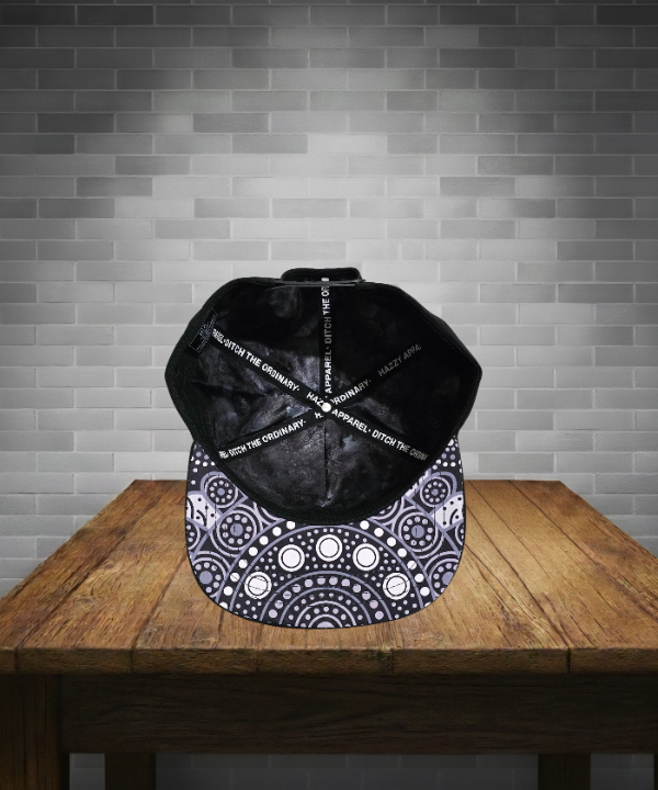 Black and white patterned cap on a wooden table with a gray brick wall background