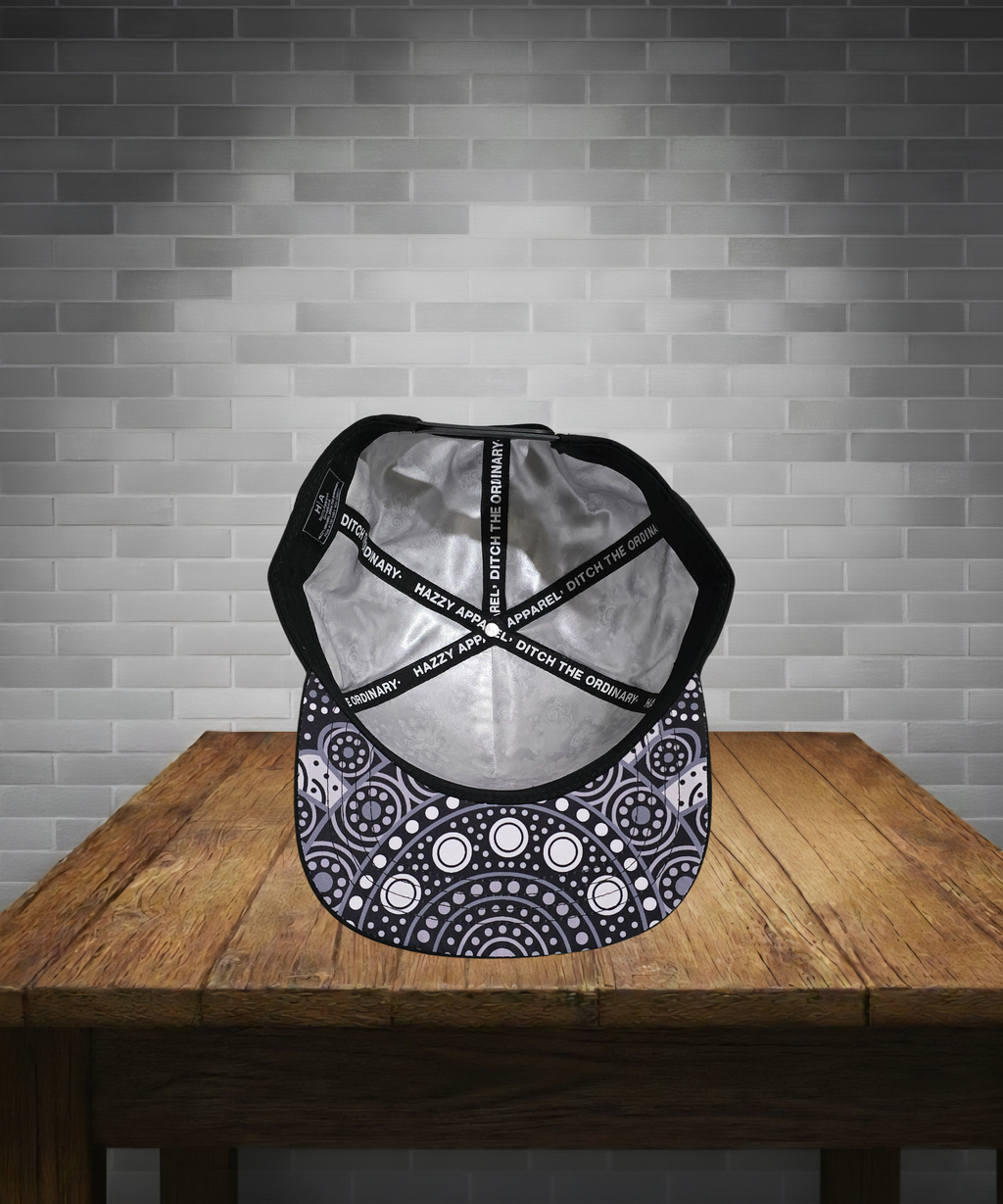 Black and white patterned cap on a wooden table with a gray brick wall background