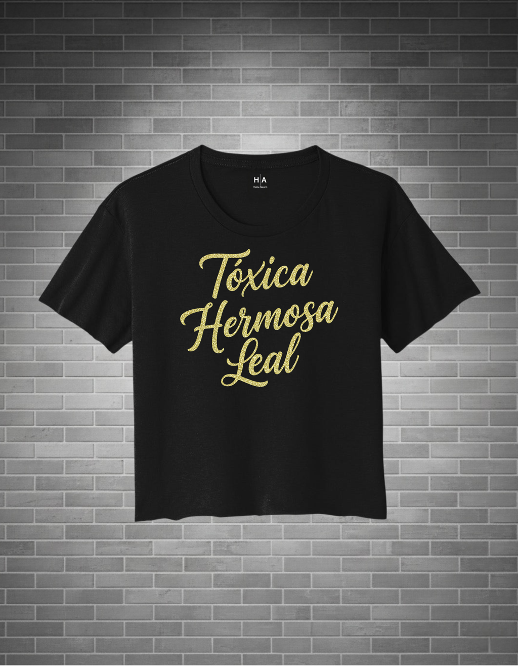 Black t-shirt with gold text on a brick wall background