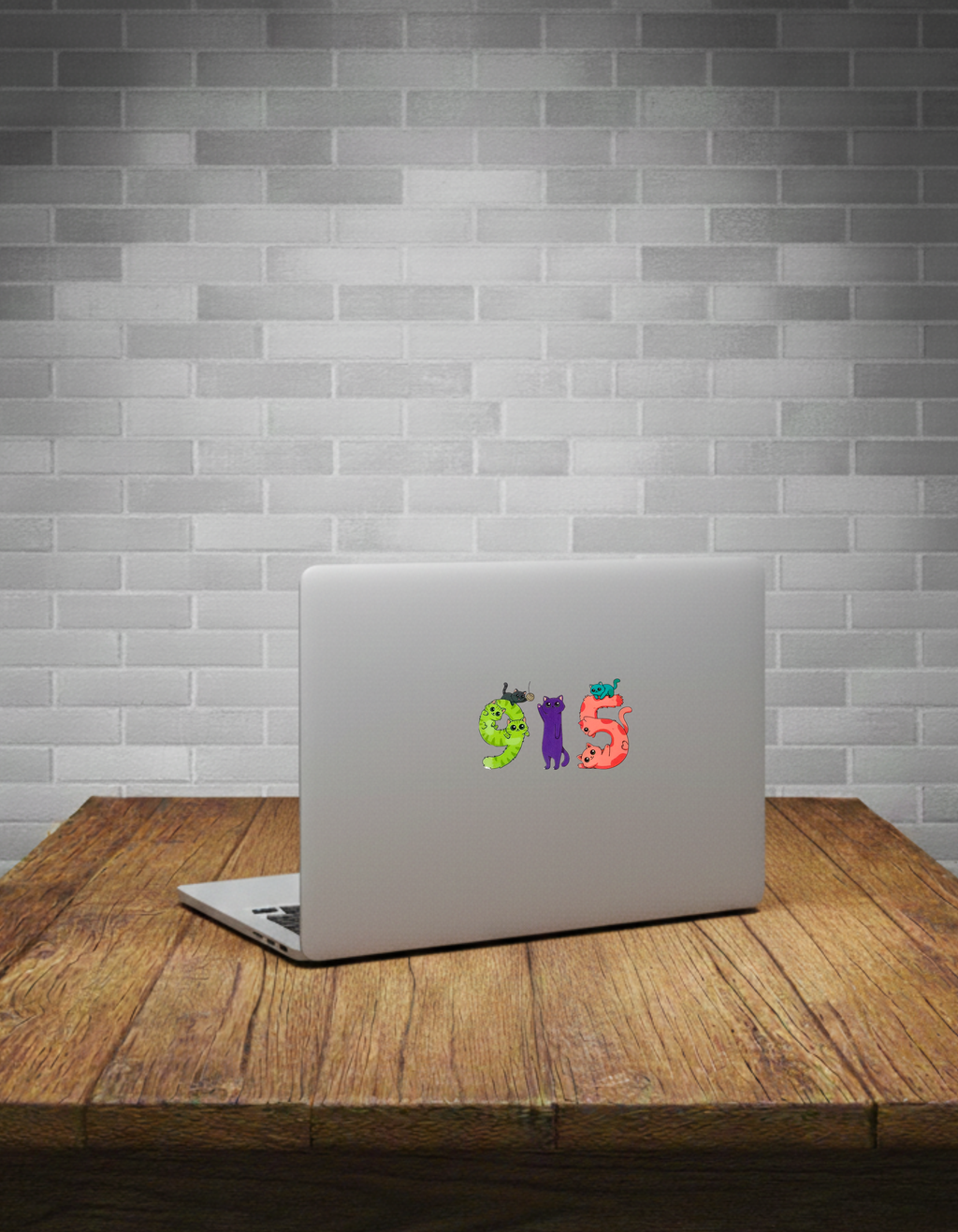 Laptop with colorful Cat sticker on a wooden table against a grey brick wall.
