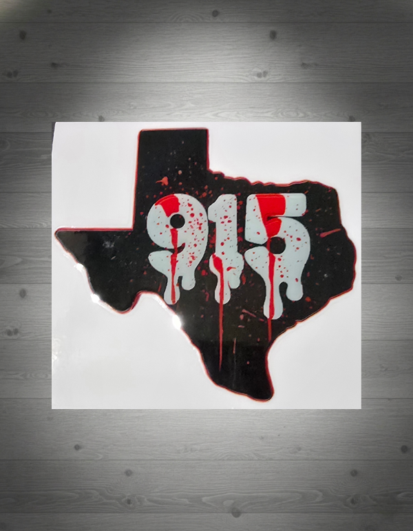 Decal of a Texas outline with '915' printed on it, featuring red splatter and white colors, on a grey wooden wall