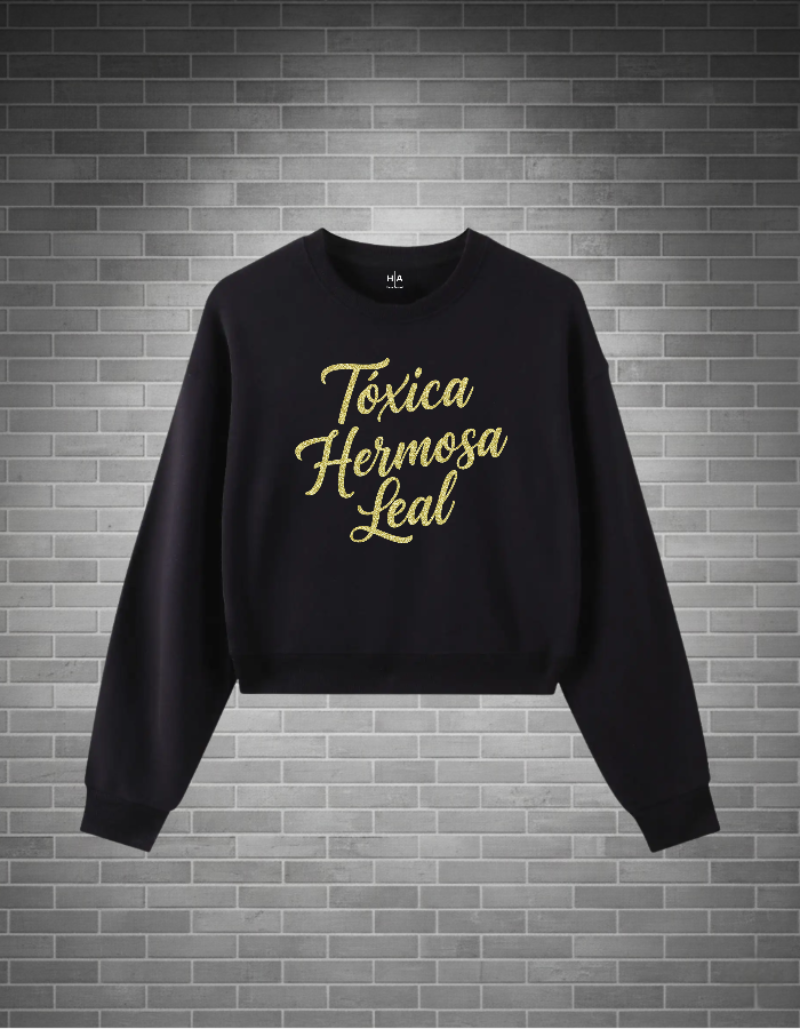 Black sweatshirt with gold text on a brick wall background