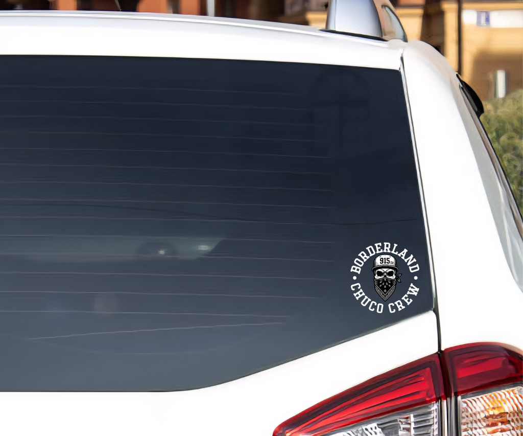 A circular black and white 'BORDERLAND CHUCO CREW' decal applied to the lower right corner of a white vehicle's rear window.