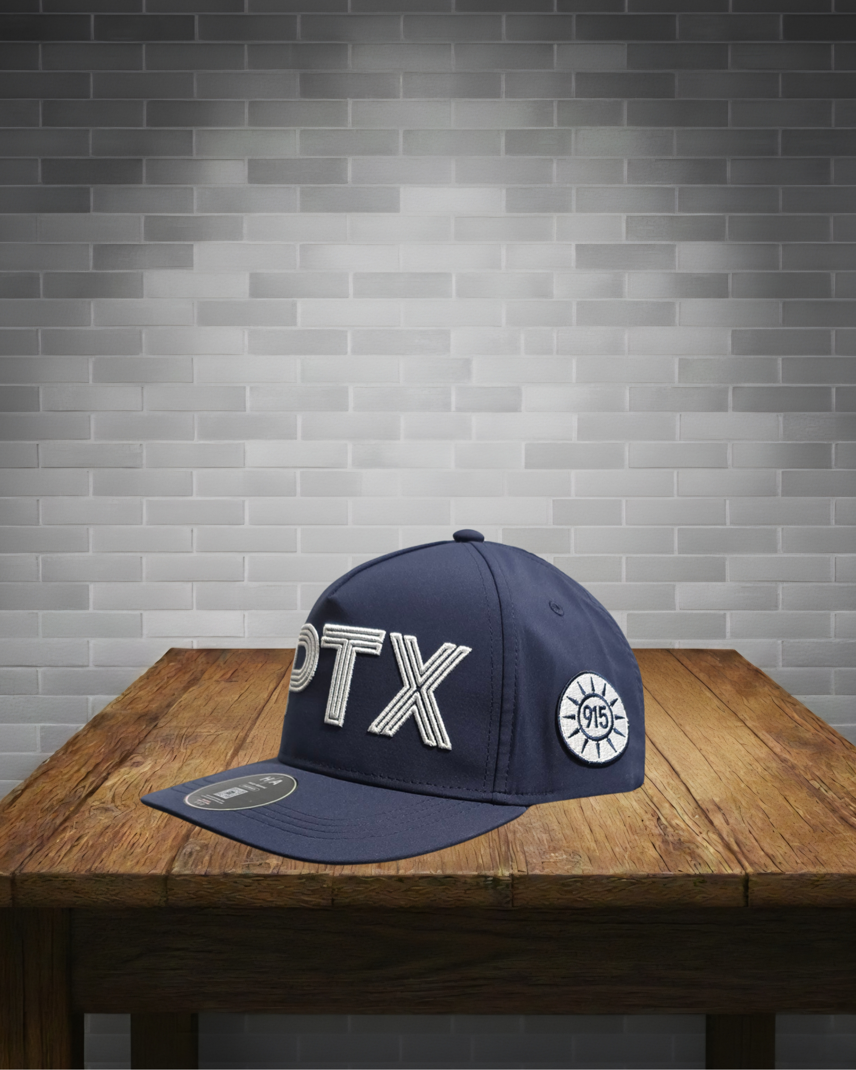 Navy blue cap with white text and logo on a wooden table against a gray brick wall.