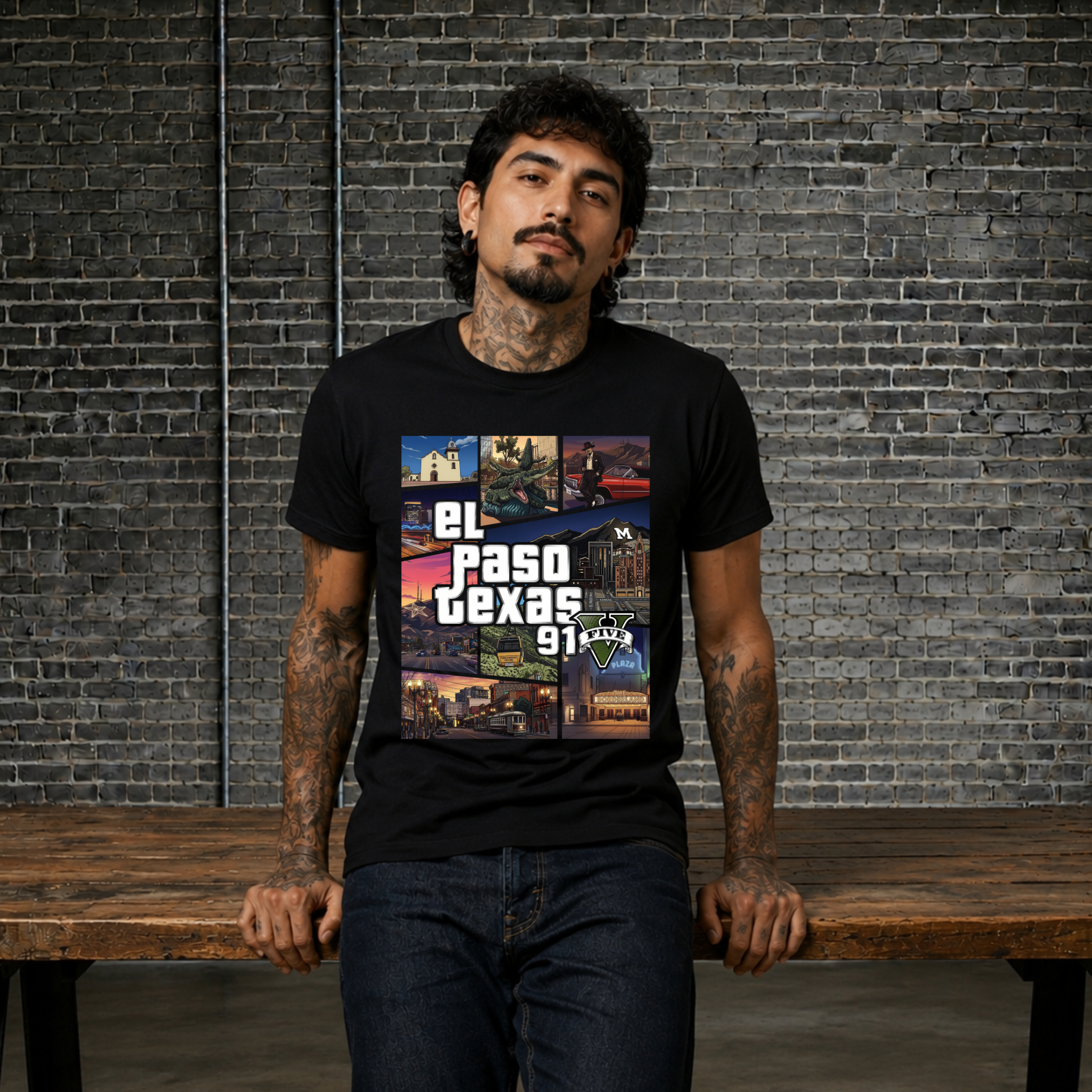 A man with tattoos wearing a black t-shirt with a 'El Paso Texas 911' graphic, standing behind a wooden bench against a gray brick wall.